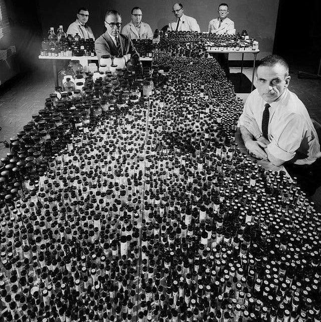 Химик компании Polaroid Говард Роджерс сидит среди крошечных бутылок с реагентами